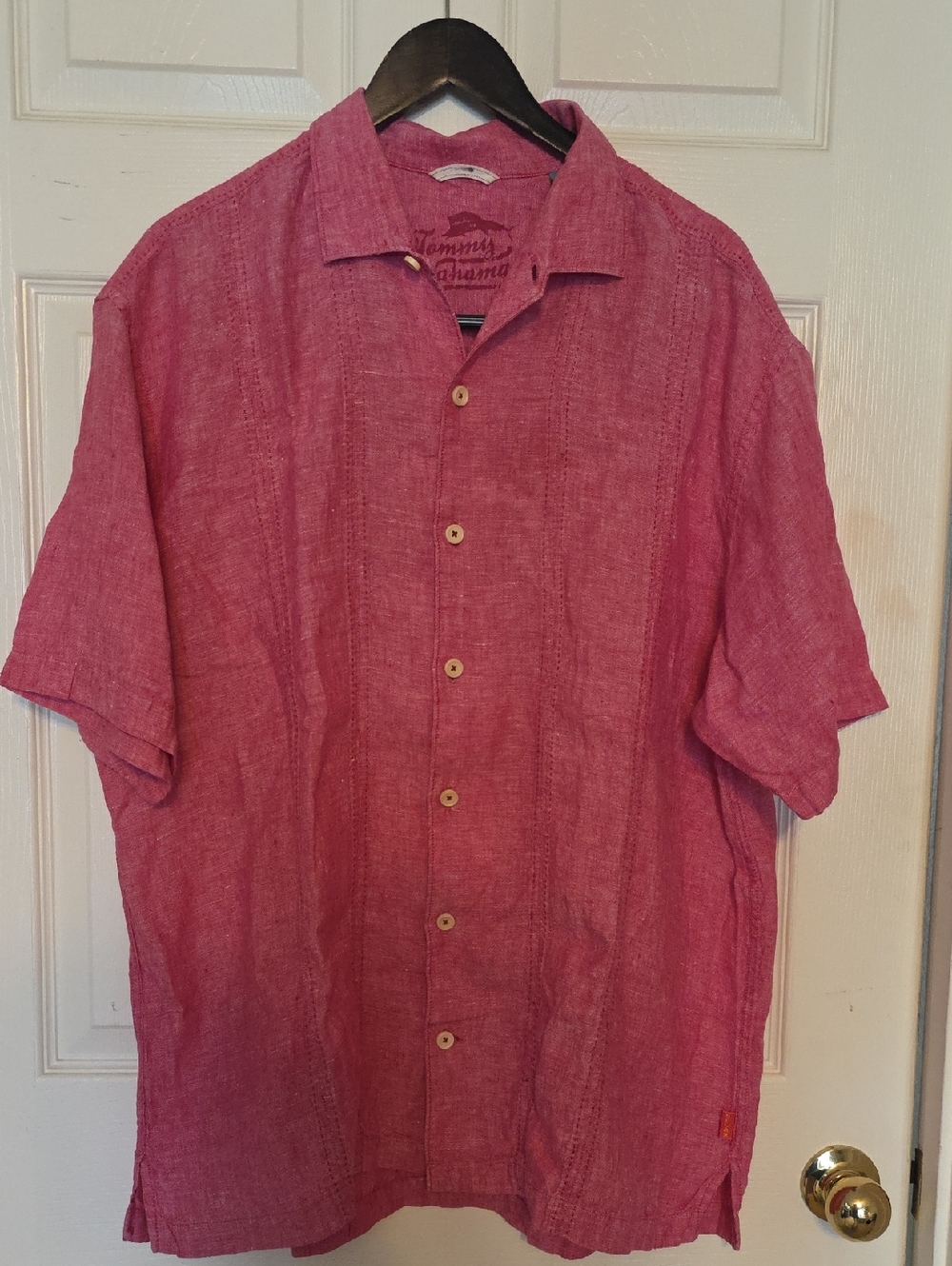 Tommy Bahama pink linen camp shirt in a short-sleeve button-down style.